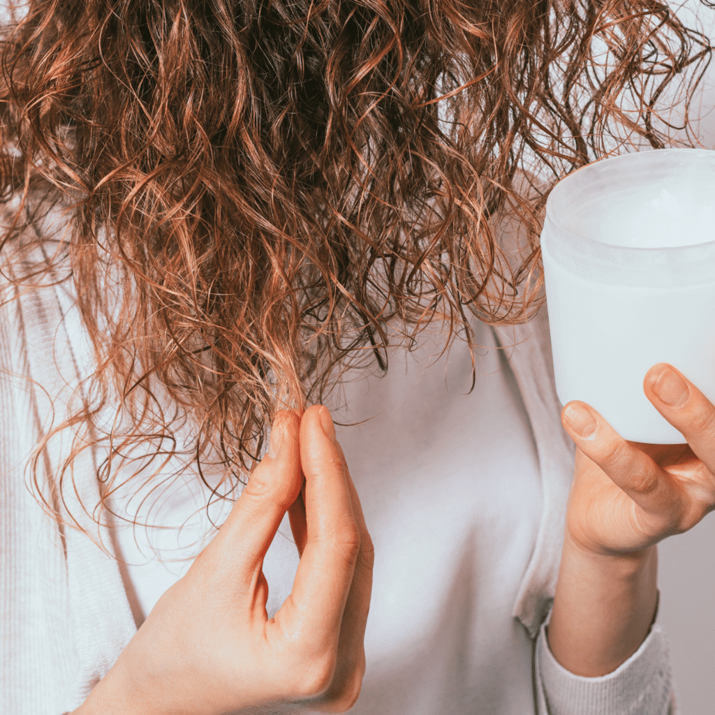 lady applying shea butter on her hair.