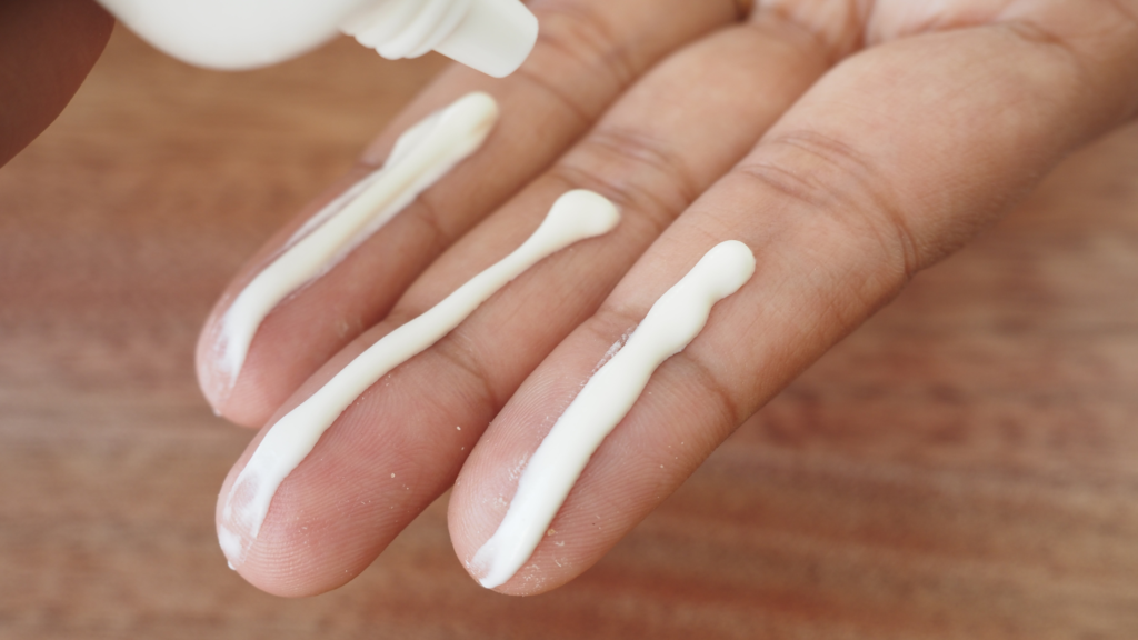 a lady's hand with sunscreen spread across.