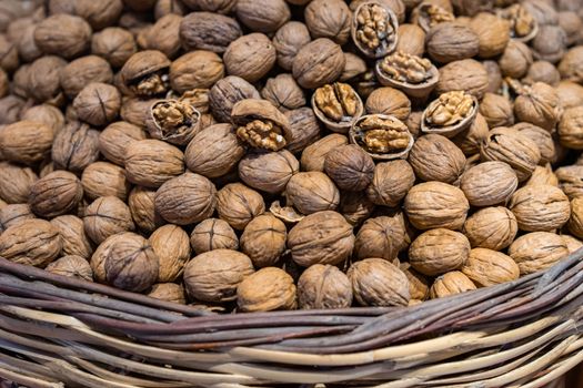 A rustic basket brimming with organic walnuts, showcasing natural and raw food photography.